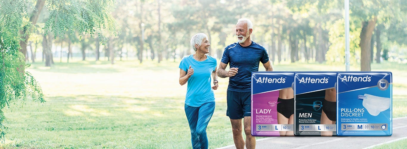 Older couple jogging in a sunny park beside packs of Attends Lady, Attends Men and Attends Pull-Ons Discreet incontinence products
